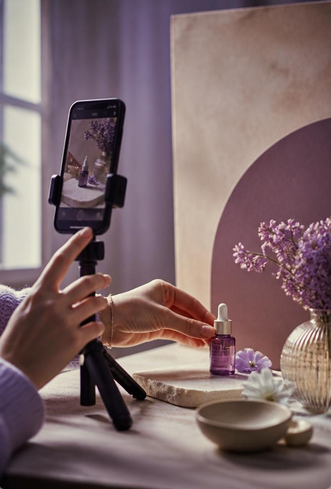 Creator filming a skincare product at a styled tabletop set